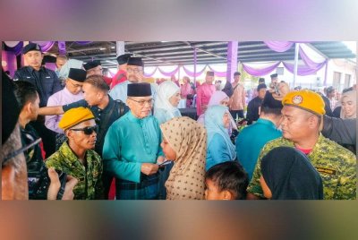 Wan Rosdy menyampaikan duit raya kepada kanak-kanak sempena Majlis Rumah Terbuka Aidilfitri DUN Jelai pada Sabtu.