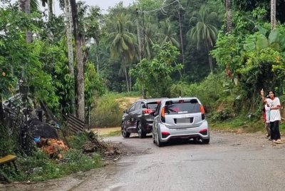 Kanak-kanak membantu menunjukkan laluan kepada pengguna jalan raya. Foto Bernama