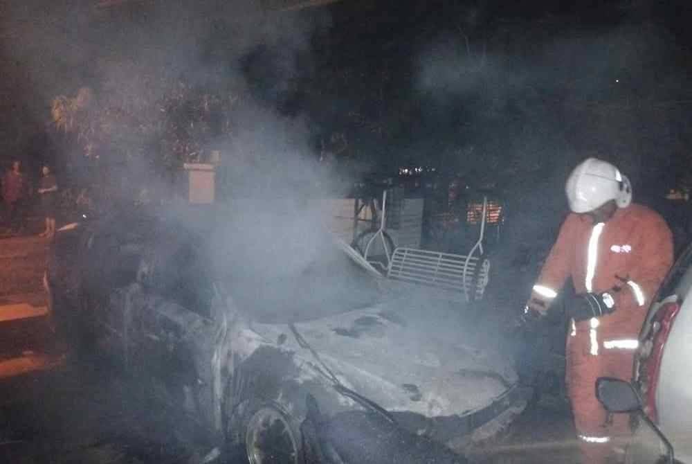 Anggota bomba memadamkan kebakaran di tempat letak kereta di Taman Murni Perdana, Paka, Dungun.