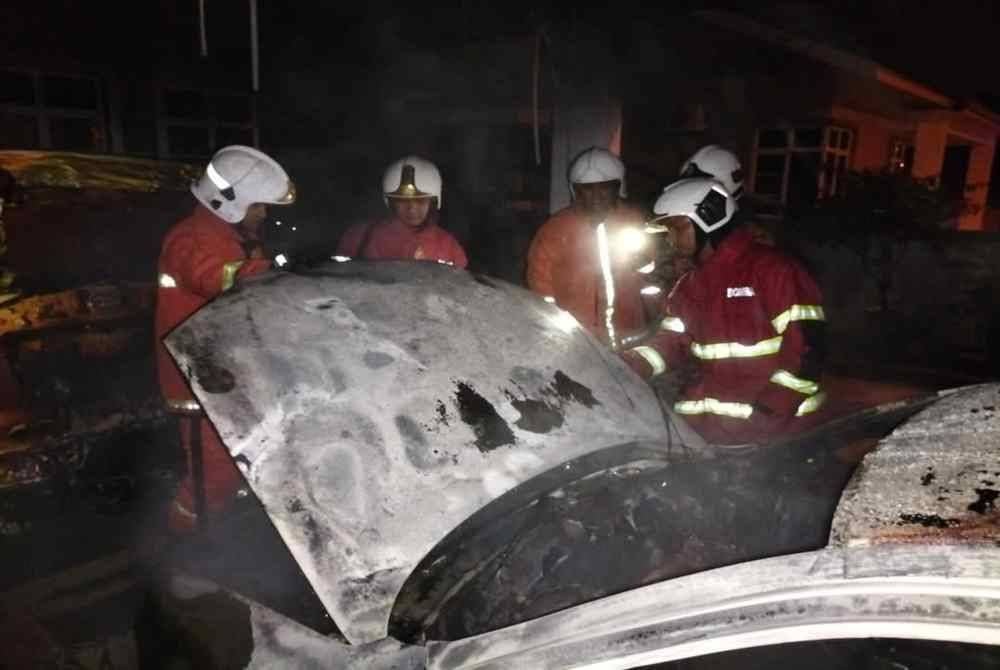 Anggota bomba memeriksa kenderaan yang terbakar di tempat letak kereta di Taman Murni Perdana, Paka, Dungun.