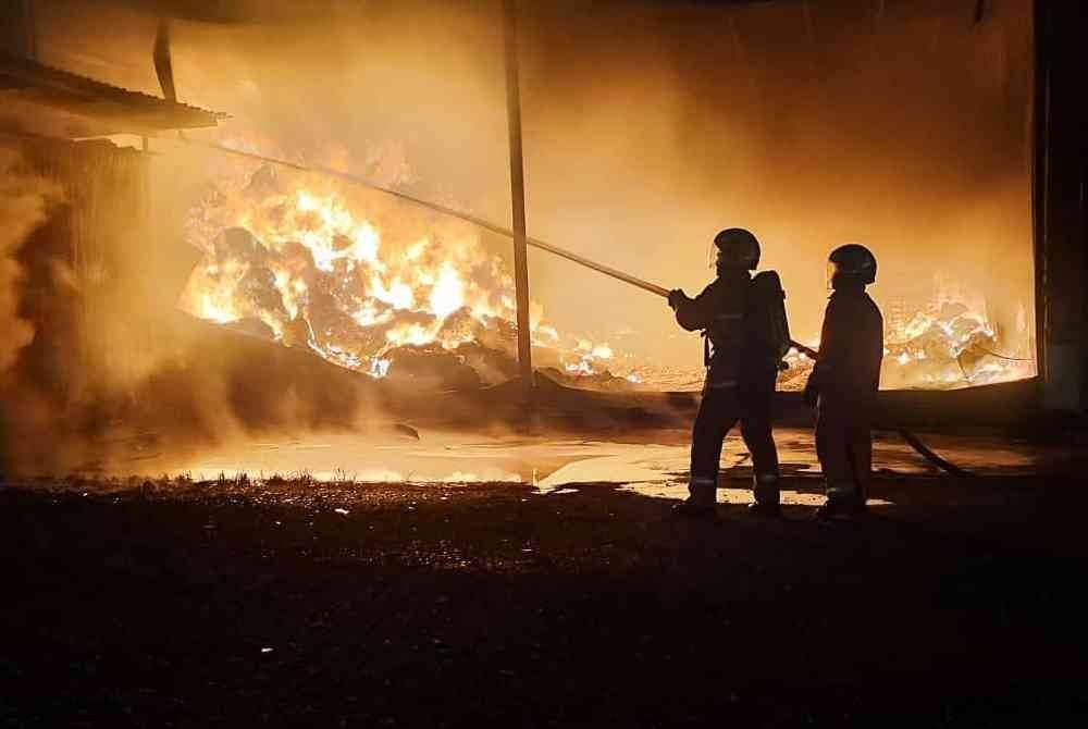 Pasukan bomba memadamkan kebakaran melibatkan kilang memproses telur masin di Trong pada Ahad. Foto JBPM Perak
