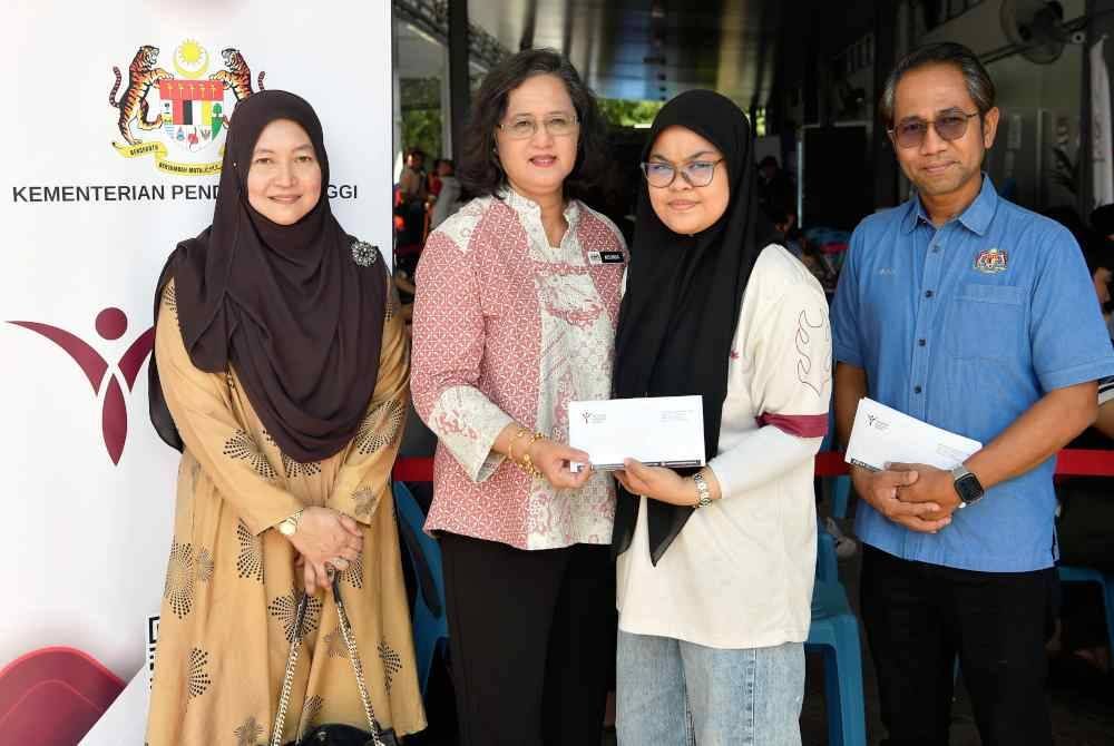 Azlinda (dua dari kiri) menyampaikan sumbangan kepada pelajar IPT yang terlibat dalam kebakaran saluran paip gas di Pusat Pemindahan Sementara (PPS) Dewan Serbaguna Masjid Putra Heights pada Ahad. Foto Bernama