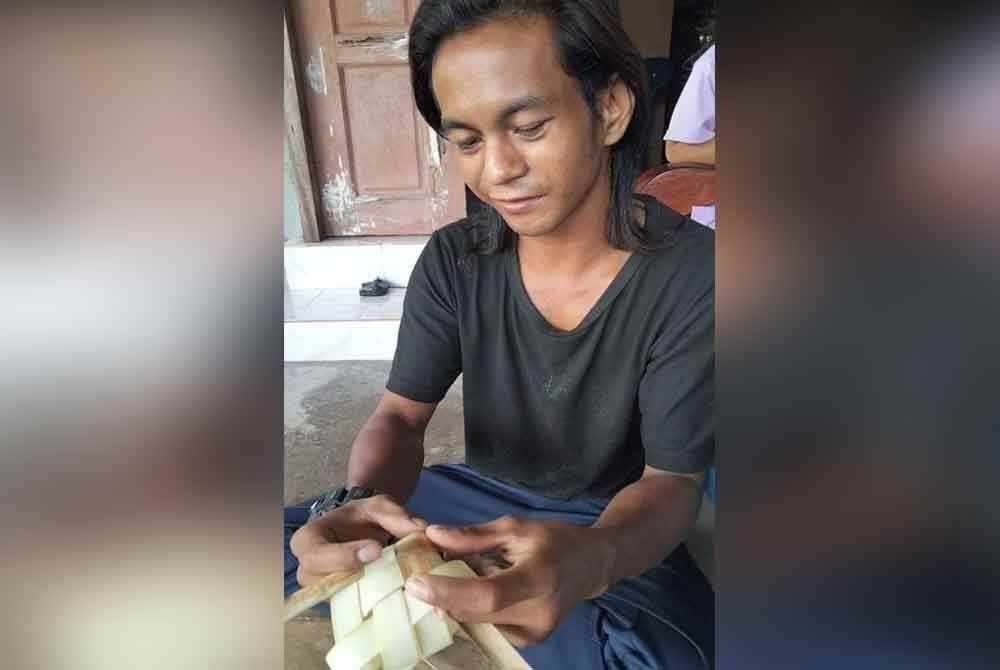 Mohamad Hairul Hazlan menunjukkan cara menganyam sarung ketupat nasi.