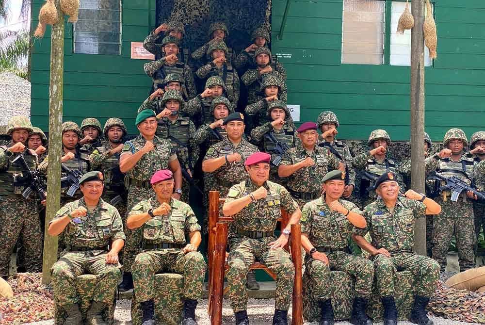 Muhammad Hafizuddeain (duduk, tengah) mengadakan lawatan ke kawasan operasi 8 Briged sempena Aidilfitri di Pos Tok' O, Rantau Panjang pada Isnin.