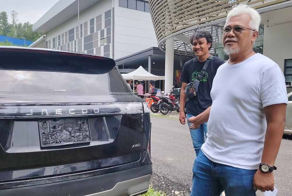 Ahmad Baharudin (kanan) menunjukkan kenderaan miliknya yang hanya mengalami kerosakan kecil dan sempat diselamatkan dalam insiden kebakaran saluran paip gas di Putra Heights.