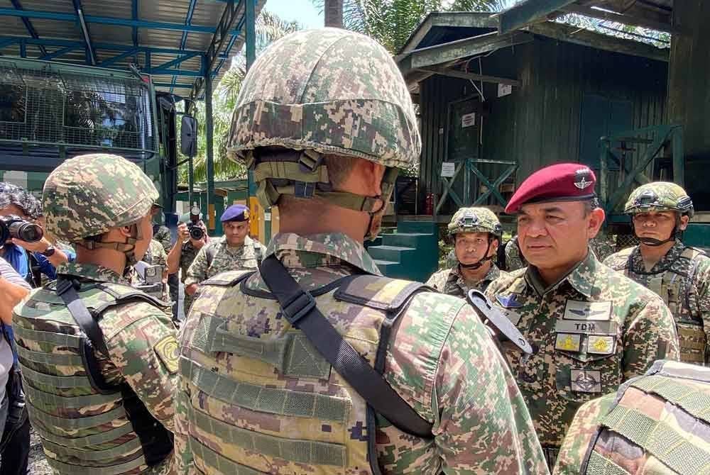 Muhammad Hafizuddeain beramah mesra dengan anggota semasa mengadakan lawatan ke kawasan operasi 8 Briged sempena Aidilfitri di Pos Tok'O, Rantau Panjang pada Isnin.