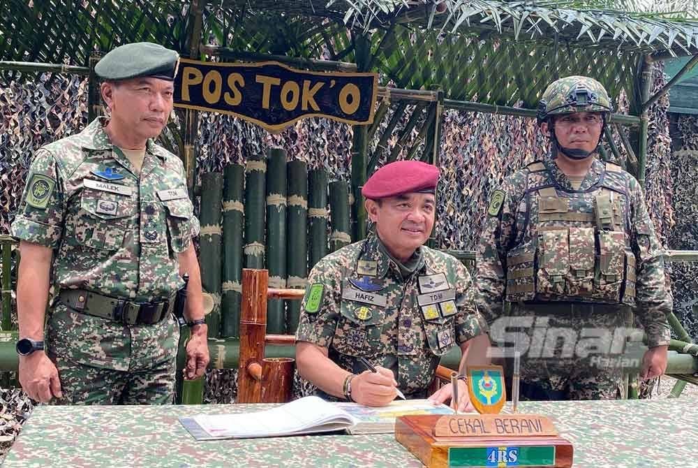 Muhamad Hafizuddeain menandatangani buku lawatan semasa mengadakan lawatan ke kawasan operasi 8 Briged sempena Aidilfitri di Pos Tok' O, Rantau Panjang pada Isnin.