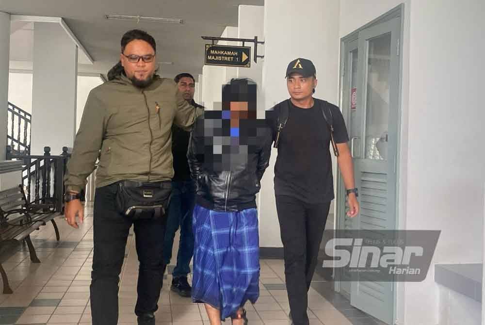 Suspek yang memakai jaket hitam dan berkain pelekat biru tiba di pekarangan mahkamah sekitar jam 3.30 petang dengan diiringi pegawai polis.