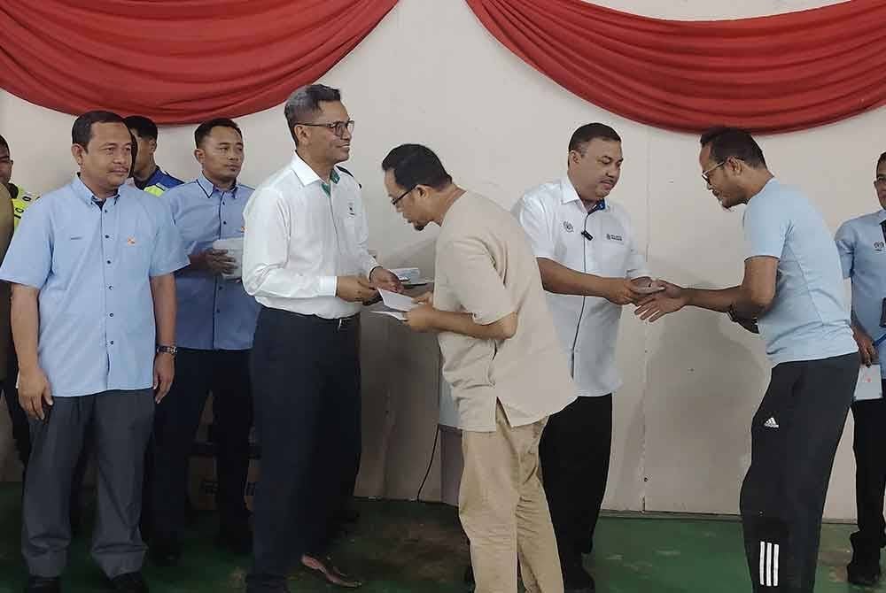 Azman (dua dari kanan) menyampaikan sumbangan kepada penduduk yang terjejas dalam tragedi kebakaran saluran paip gas di Putra Heights, pada Isnin.