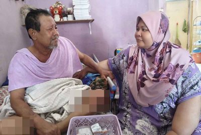 Noraini (kanan) perlu menjaga dan menyara suaminya yang mengalami strok awal tahun ini selain dua anak OKU.