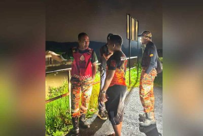 Mohd Syazwan (kiri) semasa operasi pencarian mangsa pada Ahad.