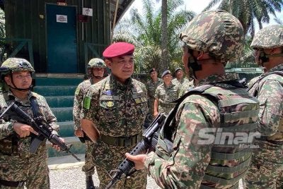Muhamad Hafizuddeain beramah mesra dengan anggota semasa mengadakan lawatan ke kawasan operasi 8 Briged sempena Aidilfitri di Pos Tok' O, Rantau Panjang pada Isnin.