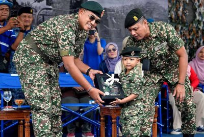 Panglima Angkatan Tentera Jeneral Datuk Mohd Nizam Jaffar (kiri) menyampaikan cenderahati kepada adik Akif Ziyan Azhar, 5, yang memakai uniform penuh anggota tentera ketika Program "Make A Wish" Kanak-Kanak Menghidapi Leukemia Bersama Angkatan Tentera di Padang Kawad Pangkalan Udara Jugra, Banting, pada Isnin. Foto Bernama