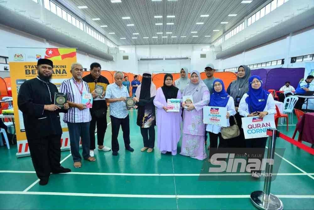 Muhammad Nasir (empat, kiri)menyerahkan sumbangan al-Quran dan bahan bacaan kepada mangsa insiden kebakaran paip gas di PPS Masjid Putra Heights pada Selasa. Foto Sinar Harian-ASRIL ASWANDI SHUKOR.