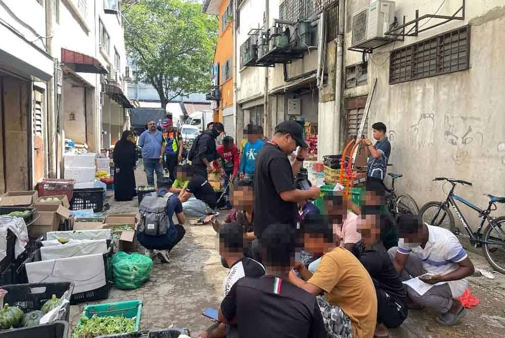 Antara penjaja warga asing yang diperiksa dalam operasi di Pasar Boring Kuala Lumpur pada Selasa.