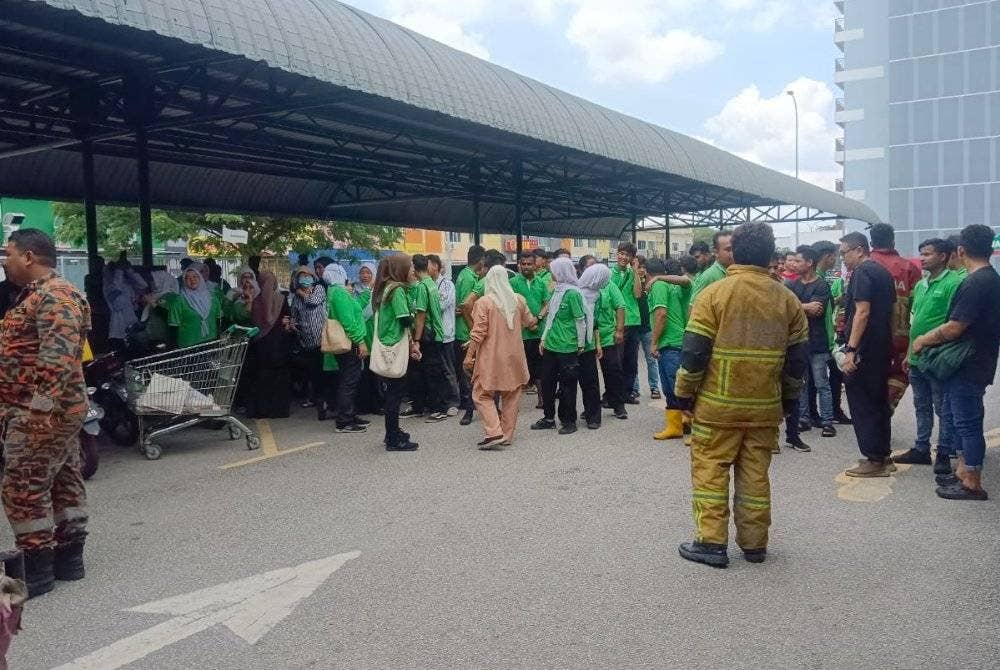 Orang ramai keluar dari sebuah pasar raya yang terbakar di bahagian bumbung di Bandar Puncak Alam di sini pada Selasa.