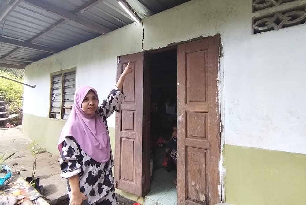 Siti Nora Akma menunjukkan bahagian rumahnya yang diceroboh kera liar walaupun pintu ditutup.