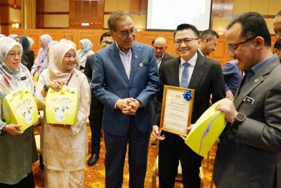 Dr Dzulkefly (tengah) beramah mesra dengan wakil kementerian selepas selesai menyerahkan mesin Automated External Defibrillator (AED) di Putrajaya pada Selasa.