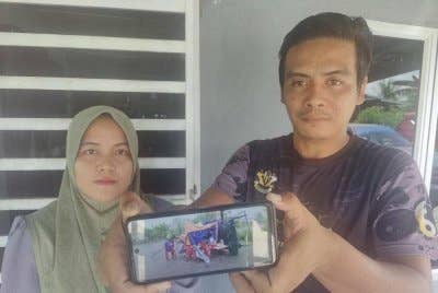 Shahrul Nazrin dan isterinya menunjukkan keadaan khemah niaga mereka yang rosak teruk akibat dibadai angin kuat dalam kejadian di Parit 4 Ban 2, Sekinchan pada Selasa.