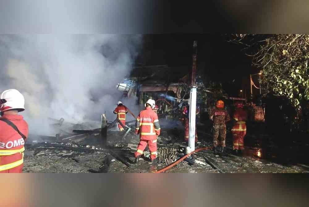 Anggota bomba berusaha memadam kebakaran dua rumah di Kampung Gelong Gajah, Kuala Terengganu malam Selasa.