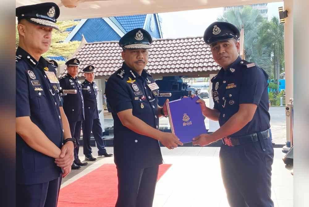 Mohd Yusoff (tengah) menyampaikan sijil penghargaan pada Perhimpunan Bulanan di Ibu Pejabat Polis Kontinjen (IPK) Kelantan di Kota Bharu pada Rabu.