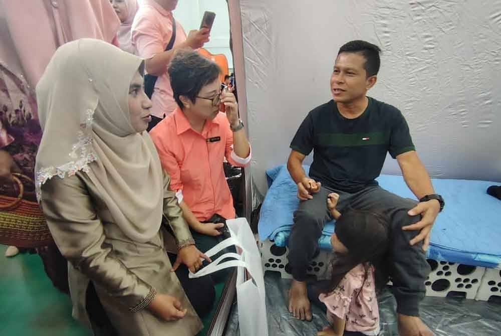 Mangsa insiden kebakaran paip gas Putra Heights, Ahmad Kamarul (kiri) ketika menerima kunjungan Masdiana (kanan).