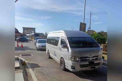 Van Thailand membawa penumpang masuk ke negara ini di negeri Kelantan.