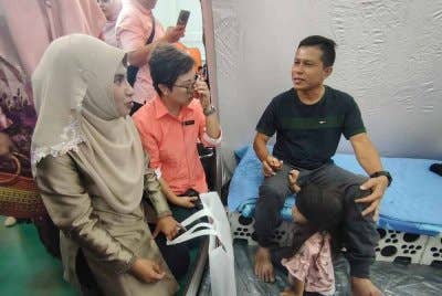 Mangsa insiden kebakaran paip gas Putra Heights, Ahmad Kamarul (kiri) ketika menerima kunjungan Masdiana (kanan).