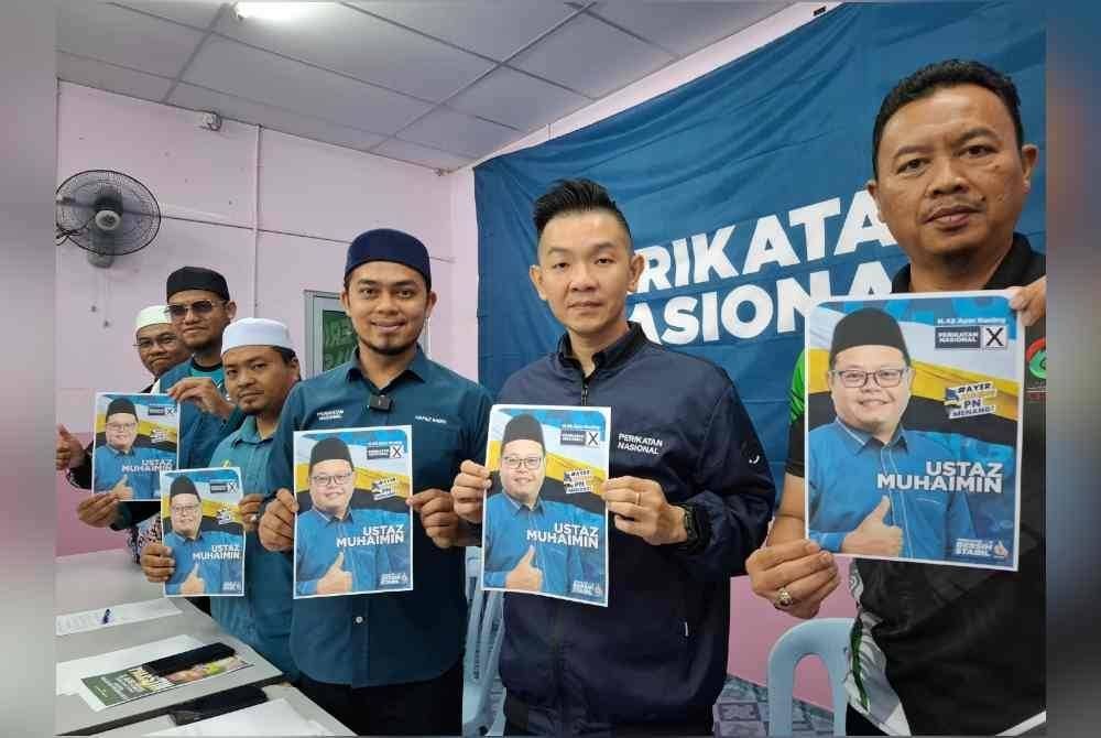Hafez (tiga dari kanan) bersama pimpinan Pemuda PN Perak menunjukkan gambar calon PN, Abd Muhaimin dalam sidang akhbar pada Khamis.
