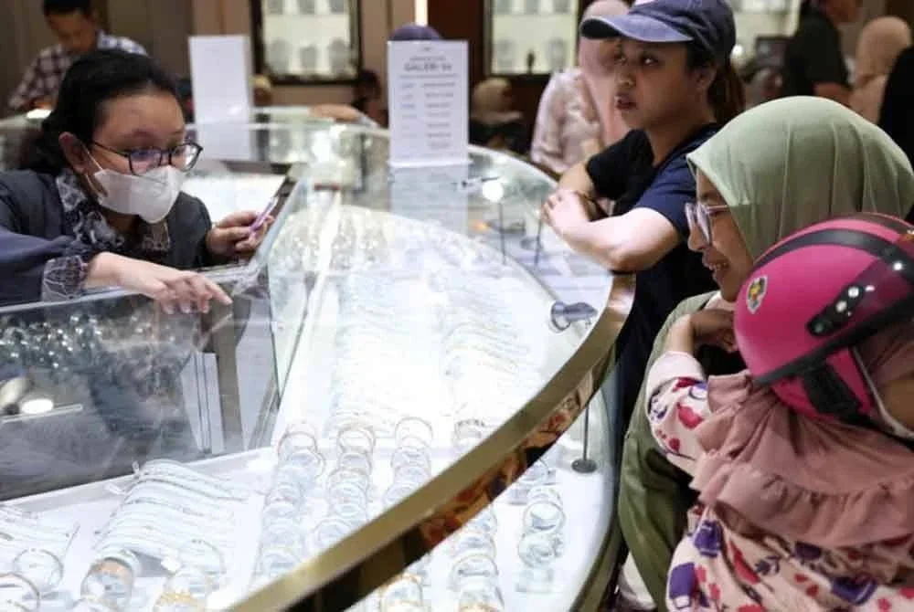 Seorang kakitangan melayani pelanggan di kedai emas dan perhiasan Galeri 24 di Jakarta. Foto Agensi