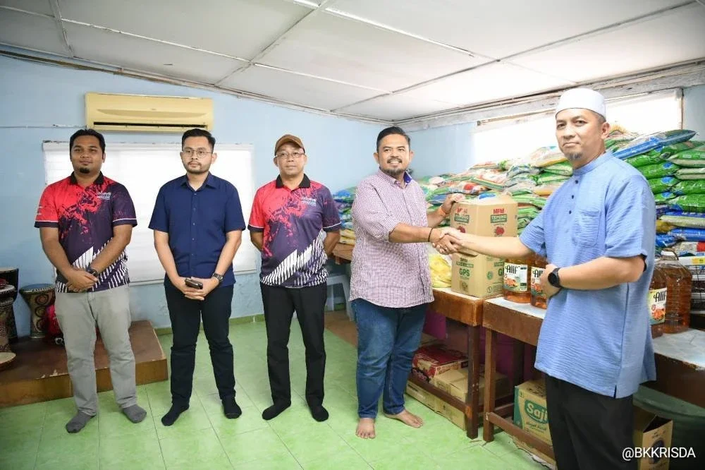 Manndzri (dua, kanan) menyampaikan sumbangan keperluan harian kepada wakil Pertubuhan Kebajikan Anak-Anak Yatim Darulaitam, Tapah.