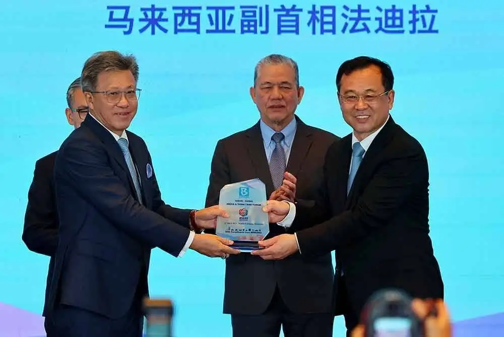 Fadillah (dua dari kanan) menyaksikan penyampaian cenderamata oleh Ketua Pengarang Agensi Berita Xinhua, Lyu Yansong (kanan), kepada Pengerusi Bernama, Datuk Seri Wong Chun Wai (dua dari kiri) pada Forum Media dan Badan Pemikir ASEAN-China yang berlangsung di Hotel InterContinental Kuala Lumpur, hari ini. - Foto: Bernama