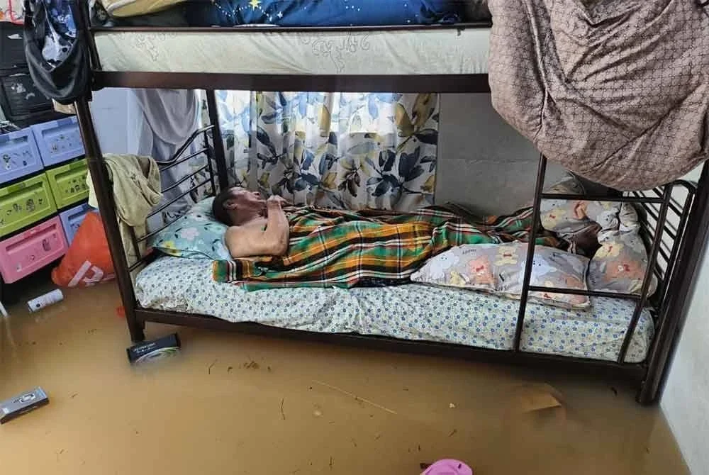 Seorang warga emas yang tidak mampu berjalan berada di atas katil berjaya diselamatkan anggota bomba semasa kejadian banjir di Jalan Mat Raji, Padang Jawa, Shah Alam, Selangor pada Jumaat. Foto: JBPM