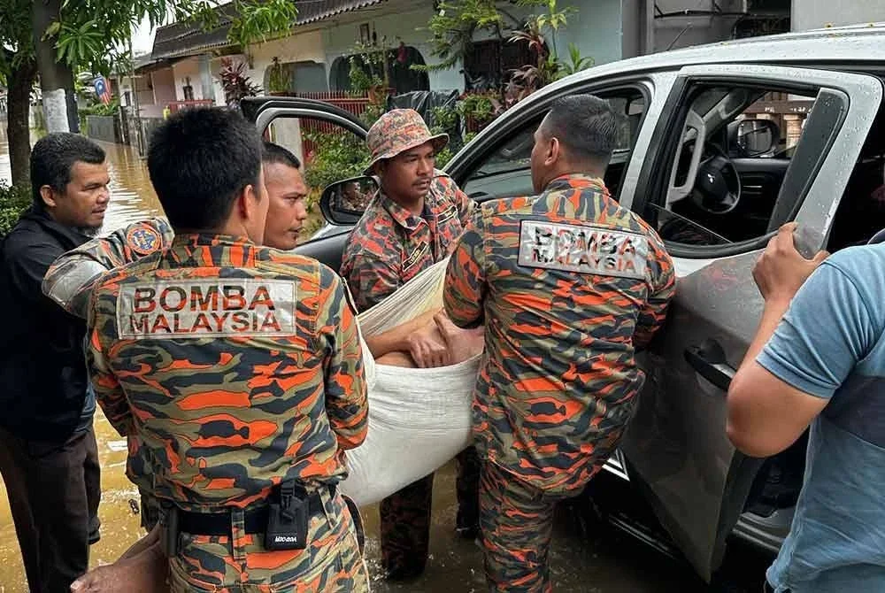 Pasukan bomba mengangkat warga emas yang tidak mampu berjalan dan dibawa ke lokasi selamat, dalam kejadian banjir di Jalan Mat Raji, Padang Jawa, Shah Alam, Selangor pada Jumaat. - Foto: JBPM.