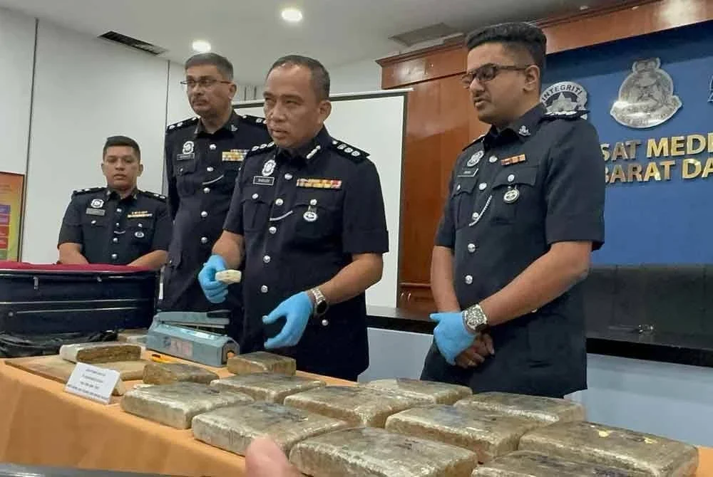 Sazlee (dua dari kanan) menunjukkan dadah yang dirampas ketika sidang akhbar di Ibu Pejabat Polis Daerah Barat Daya, di sini pada Jumaat.