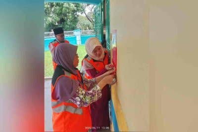 Penguatkuasa JKM Johor menampal notis arahan berhenti operasi terhadap sebuah premis rumah yang dijadikan sebagai pusat jagaan kanak-kanak di Kangkar Pulai. - Foto Khirin-Nisa
