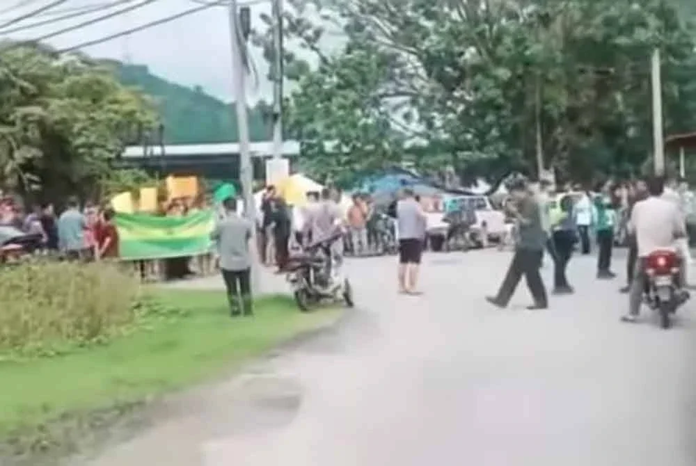 Tangkap layar pekebun-pekebun yang bertindak menghalang laluan pihak penguat kuasa dengan membawa kain rentang.
