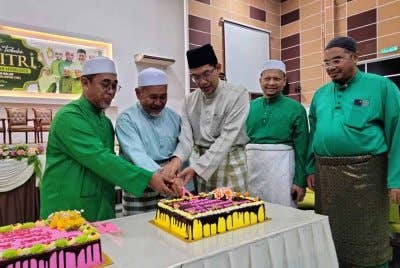 Tuan Ibrahim (dua, kiri) memotong kek sempena Majlis Sambutan Hari Raya Aidilfitri Parlimen Kubang Kerian di Salor pada Jumaat.