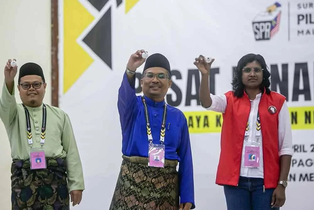 Calon BN, Dr Mohamad Yusri Bakir (dua dari kiri), calon PSM, Bawani KS, (kanan) dan calon PN, Abdul Muhaimin Malek (kiri) menunjukkan nombor calon masing-masing ketika sesi pengundian di Dewan Merdeka hari ini. - Foto: Bernama