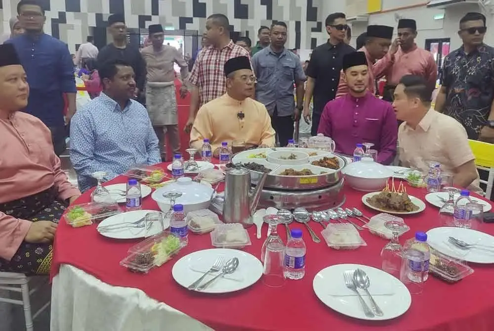 Amirudin (tiga dari kiri) menikmati juadah semasa Majlis Tautan Kasih Komuniti Sabak Bernam di Depan seri Nakhoda Simpang Empat, Bagan Nakhoda Omar pada Ahad.