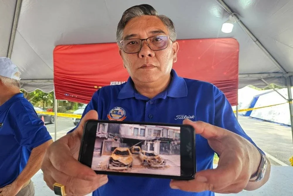 Ka Kim menunjukkan gambar kediaman serta kenderaan miliknya yang musnah keseluruhan akibat tragedi kebakaran saluran paip gas di Putra Heights, Subang Jaya.