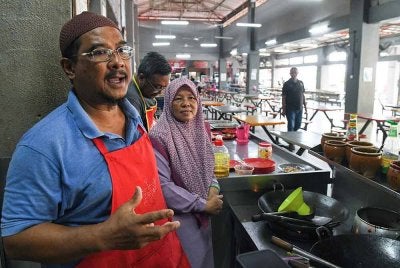 Peniaga makanan, Ismail Abdul Rahman, bersama isterinya, Latifah Othman, 57, meluahkan rasa sedih mereka atas pemergian Tun Abdullah ketika ditemui di pasar awam Kepala Batas pada Selasa. Foto Bernama