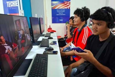 Muhammad Afif Quyairi (kanan) bersama rakan pasukan, Alif Hakeem dan Muhammad Danish Hakimie menggunakan kemudahan NADI Air Kuning sebagai platform mengasah bakat dalam e-sukan MLBB.