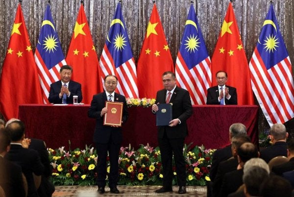 Anwar (kanan) bersama Presiden China, Xi Jinping (kiri) menyaksikan Majlis Pertukaran Memorandum Persefahaman antara Kerajaan Malaysia dan Kerajaan China, yang diwakili oleh Menteri Pengangkutan, Anthony Loke (dua, kanan) dan Duta Besar China ke Malaysia, Ouyang Yujing (dua, kiri) di Kompleks Seri Perdana, pada Rabu. Foto Bernama