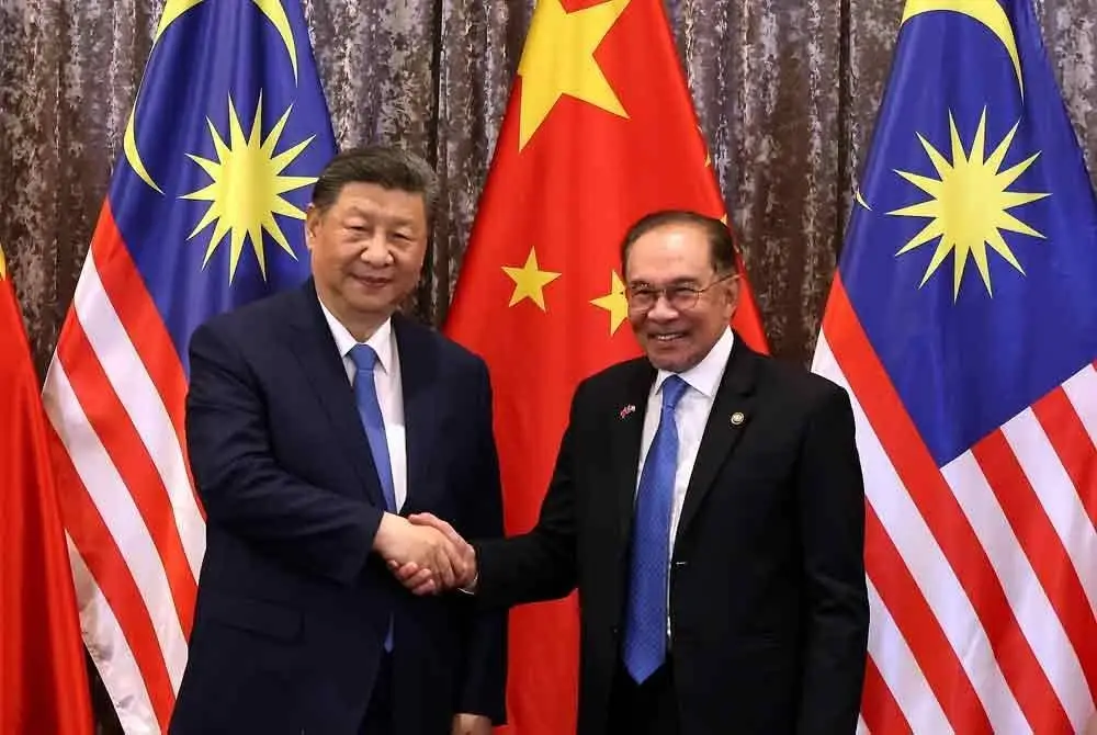 Perdana Menteri, Datuk Seri Anwar Ibrahim (kanan) bersalaman dengan Presiden China Xi Jinping pada Majlis Menandatangani Memorandum Persefahaman (MoU) sempena Lawatan Negara Presiden China ke Malaysia di Kompleks Seri Perdana pada Rabu. Foto Bernama