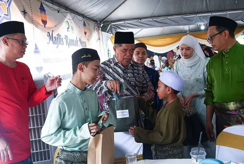 Mohamad (tiga dari kiri) turut menyantuni kanak-kanak dari Madrasah Tarbiyah Islamiyah sempena Majlis Ramah Mesra Hari Raya Aidilfitri di pekarangan PPK Tapah pada Khamis.