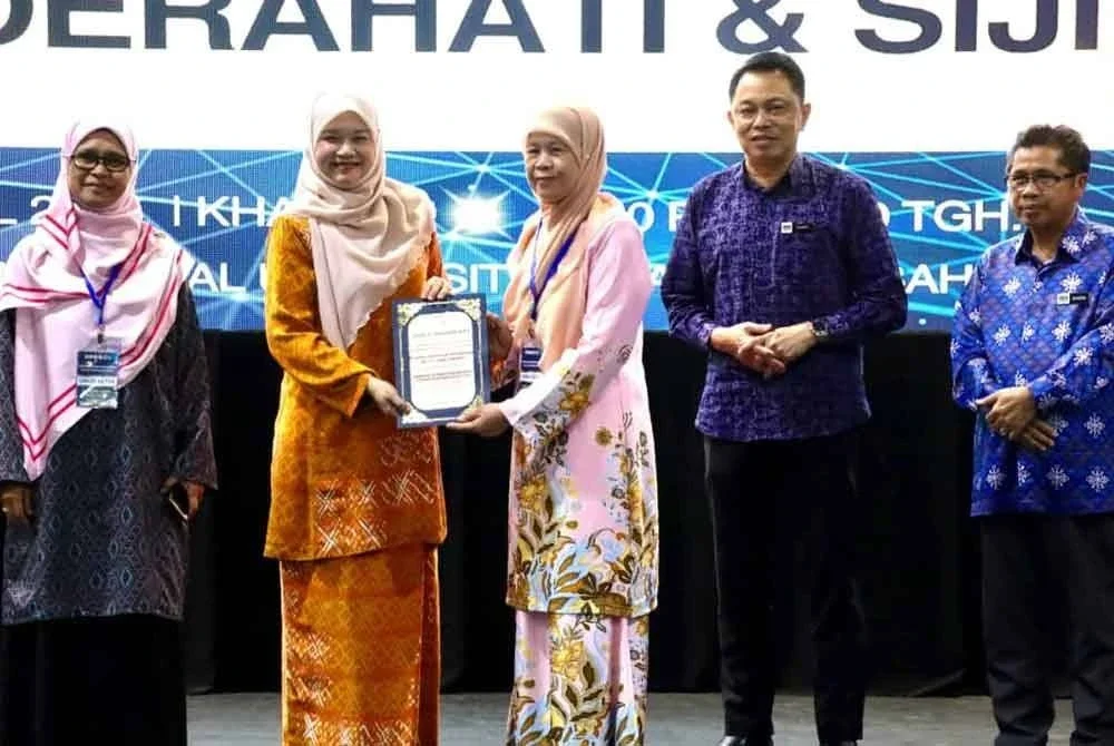 Fadhlina (dua dari kiri) menyampaikan sijil kepada peserta dalam ‘Seminar Kepimpinan Madani: Cakna Pendidikan Digital’ di Dewan Resital UMS di Kota Kinabalu.