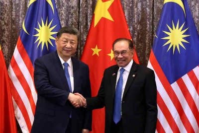 Perdana Menteri, Datuk Seri Anwar Ibrahim (kanan) bersalaman dengan Presiden China Xi Jinping pada Majlis Menandatangani Memorandum Persefahaman (MoU) sempena Lawatan Negara Presiden China ke Malaysia di Kompleks Seri Perdana pada Rabu. Foto Bernama