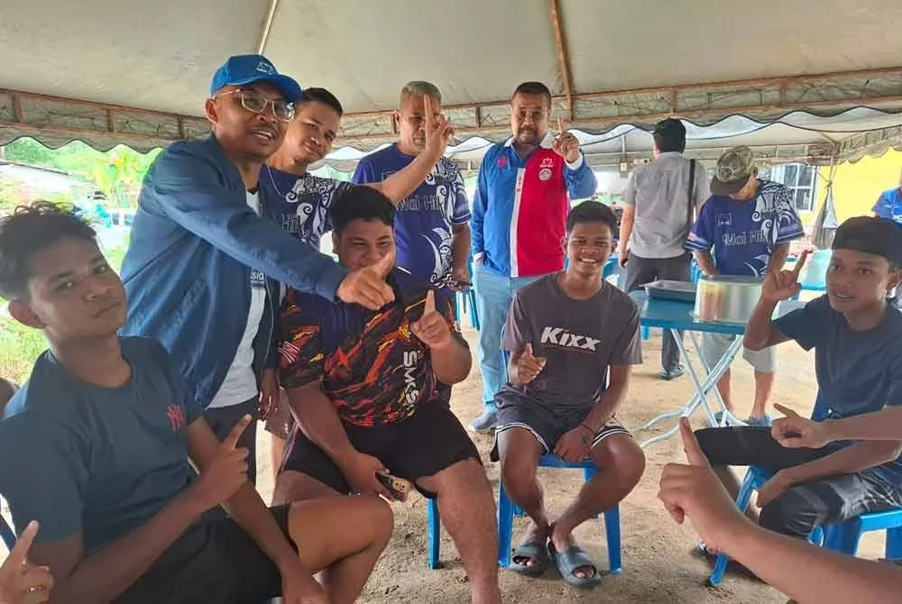 Mohamad Yusri (berdiri kiri) bersama kumpulan belia Kampung Orang Asli Sungai Kurong Dalam sempena kempen PRK DUN Ayer Kuning.