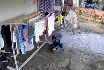 Tangkap layar rakaman CCTV perlakuan suspek mencuri pakaian dalam di ampaian rumah mangsa.